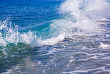 powerful blue foamy wave runs in a coast
