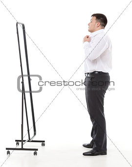 Overweight man admiring himself in a mirror