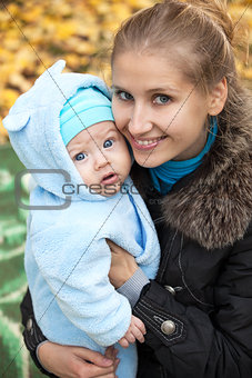 Young woman with baby in autumn park