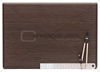 Metal measuring devices on wooden plate including ruler and comp