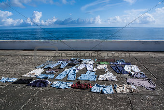 Drying clothes on the pavement at seafront in Baracoa