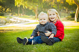 Little Girl with Baby Brother Wearing Coats at the Park 