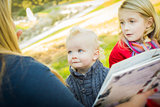 Mother Reading a Book to Her Two Adorable Blonde Children 
