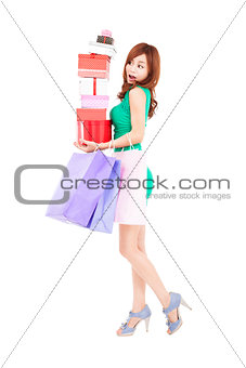 surprised young woman holding gift boxes and shopping bags