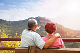 senior couple sitting on the bench looking the nature view