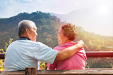 senior couple sitting on bench in nature park