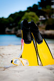 yellow fins and snorkelling mask on beach in summer