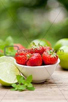 fresh tasty sweet strawberries and green lime outdoor in summer