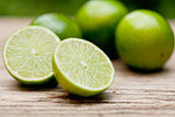 green fresh lime on wooden table macro closeup outdoor