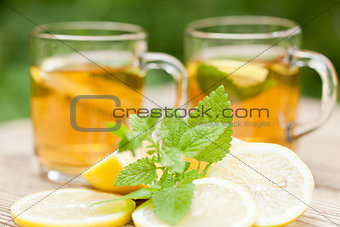 fresh tasty hot tea lemon and mint outdoor in summer 