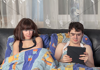 Young couple with tablet PC in their bed