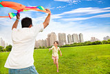 happy family playing colorful kite  in the city park