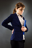 Portrait of a young businesswoman with back pain