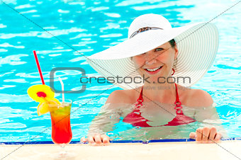 young girl in a white hat in the swimming pool