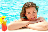 a beautiful young girl at the edge of the pool smiling