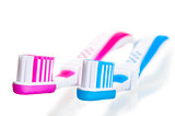 blue and pink toothbrushes lying on a white background
