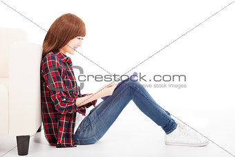 young woman reading a book and sitting on the floor