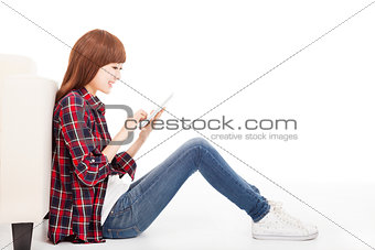 young woman using tablet and sitting on the floor