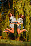 two teenage girls jumping