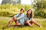two girlfriends sitting on grass