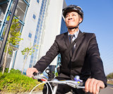 smiling businessman riding a bicycle to workplace