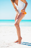 Closeup on young woman applying sun screen creme on beach