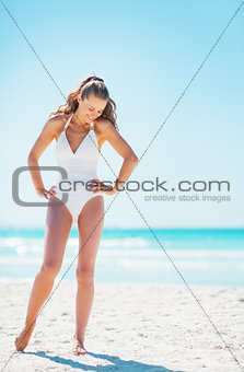 Full length portrait of happy young woman on beach