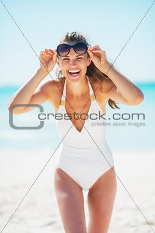 Portrait of smiling young woman in sunglasses on beach
