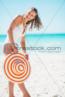 Smiling young woman with hat on beach