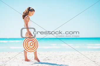 Full length portrait of young woman with hat on beach