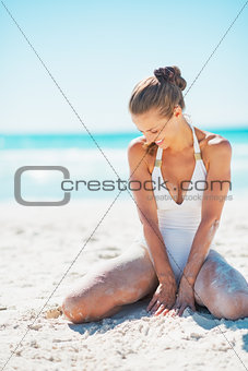 Happy young woman sitting on beach
