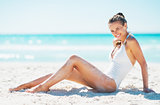 Smiling young woman sitting on beach