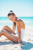 Portrait of smiling young woman sitting on beach