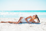 Relaxed young woman laying on beach
