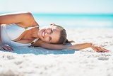 Portrait of smiling young woman laying on beach