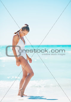 Full length portrait of young woman on sea shore