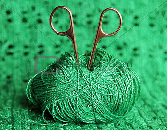 scissors in a ball of green yarn