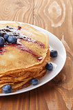homemade blinis or crepes with blueberries and jam