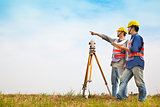 Surveyor engineer making measure with partner on the field