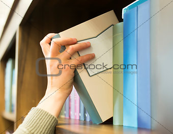 Hand pulling a book off the shelf
