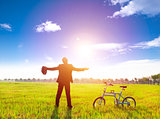 businessman relaxing in green land and sun with bicycle