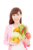 smiling young woman holding fruits and vegetables