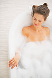 Relaxed young woman laying in bathtub