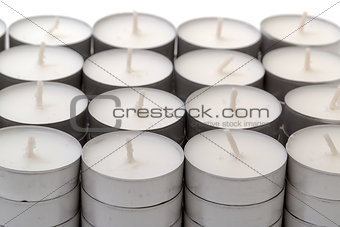 Rows of white wax tea light candles