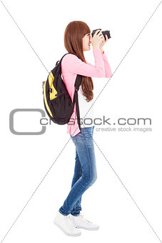 full length young girl taking a picture using digital camera