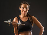 Smiling woman lifting a dumbbell