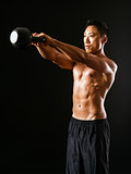 Muscular man working out with kettle bell