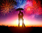 Couple kissing under umbrella with firework in the sky