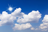 Blue sky with white clouds and sun 