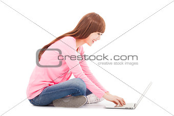 Smiling young woman sitting and typing on a laptop